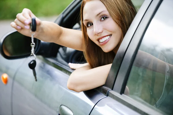 Retrato jovem atraente mulher sentado salão automóvel mão ke — Fotografia de Stock