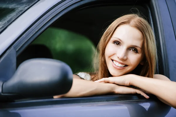 美しい若い女性は若い座っている車 ストック画像