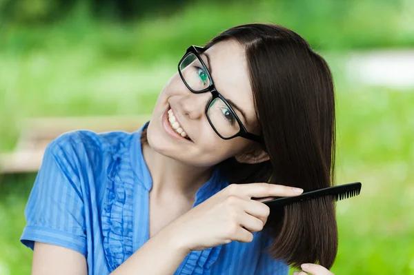 Portrait young beautiful girl glasses combs hair — Stock Photo, Image