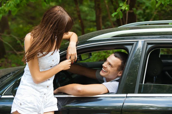 Młody przystojny mężczyzna siedzący samochodu mówi kobieta — Zdjęcie stockowe