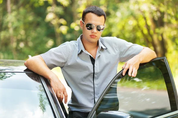 Aantrekkelijke jonge ernstige man auto — Stockfoto