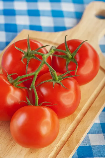 Větvička červená rajčata prkénku — Stockfoto