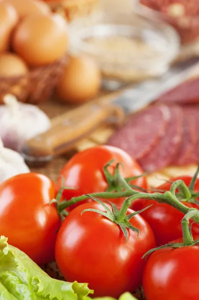 Appetitanregende Lebensmittel (Zweig rote Tomaten, Salat, Knoblauch, Wurst, E — Stockfoto