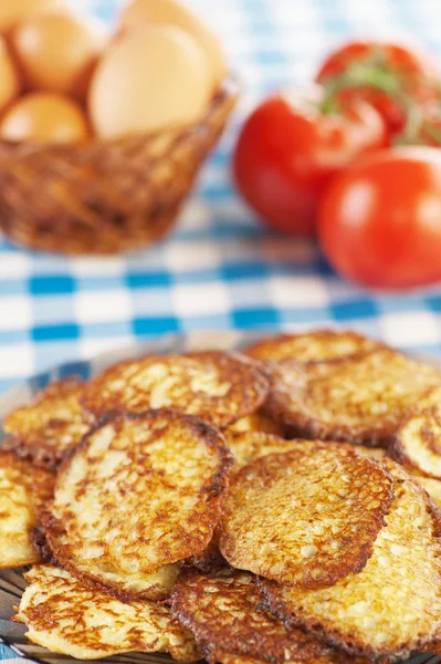 Closeup heerlijke gebakken, beignet, takje rode tomaten, rieten mand — Stockfoto