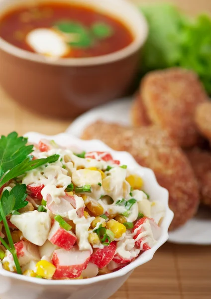 Delicious dinner closeup bowl(crab salad,burgers,borscht) — Stock Photo, Image