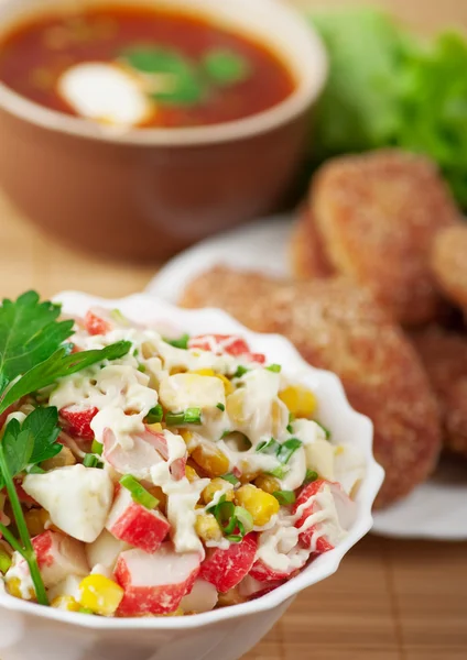 Delicious dinner closeup bowl(crab salad,burgers,borscht) — Stock Image Delicious dinner closeup bowl(crab salad,burgers,borscht) Stock Photo