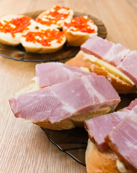 Närbild smörgåsar röd kaviar, ost, skinka — Stockfoto