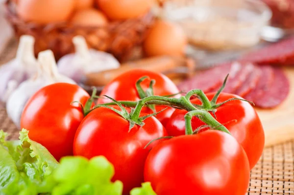 Potraviny (rajčata, hlávkový salát, česnek, salám, koření, vejce) — Stock fotografie