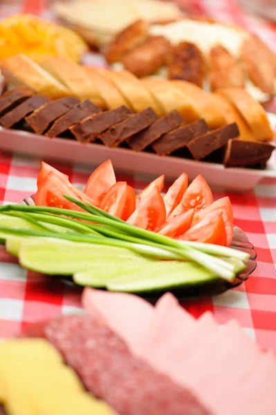 Abundance food cheese,sausage,bread, green onions,tomatoes, cucu — Stock Photo, Image