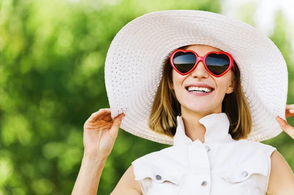 Stående ung charmig kvinna vit hatt röda solglasögon — Stockfoto