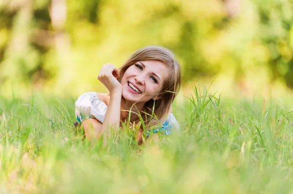 Porträt hübsche junge Frau liegend Gras — Stockfoto