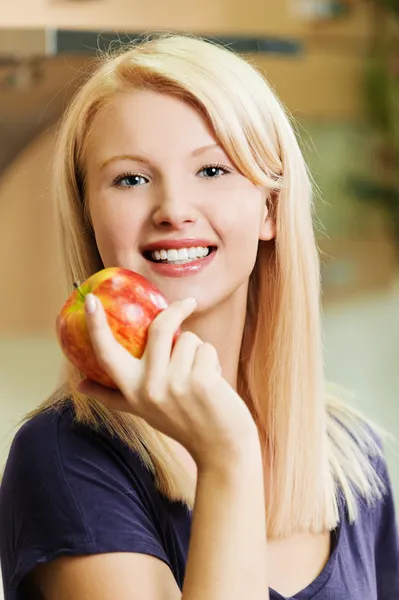 Blondin håller ett äpple — Stockfoto