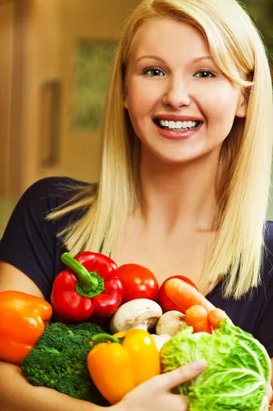 Kvinna med grönsaker i händerna på — Stockfoto