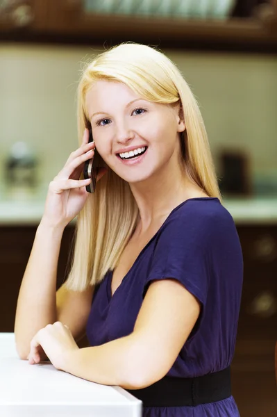 Blondin i köket med mobiltelefoner — Stockfoto