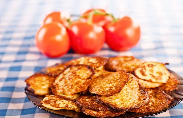 Still Life: fried fritters and tomatoes checkered tablecloths on — Stock Photo, Image