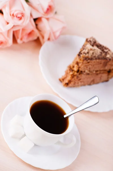 Натюрморт: чашка кофе, торт и розы — стоковое фото