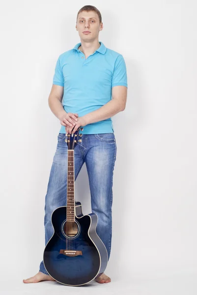 完整长度的年轻英俊的男人用蓝色吉他 — 图库照片