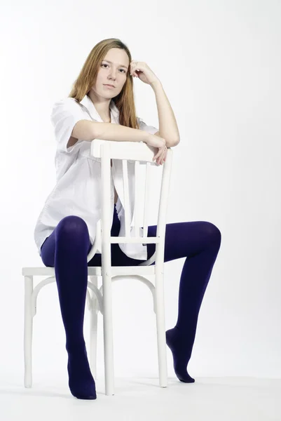 Vacker ung kvinna sitter på en stol — Stockfoto