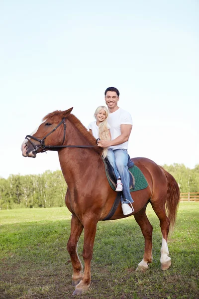 Holčička s otcem na koni — Stock fotografie