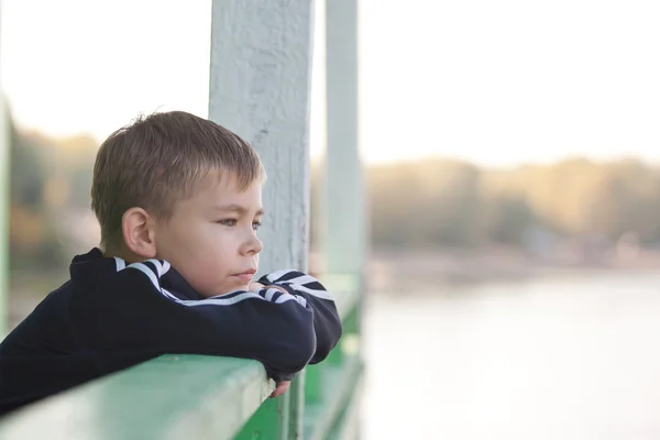Young boy leaning on railing — Stock Photo, Image