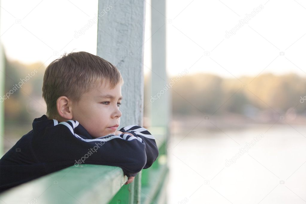 Young boy leaning on railing