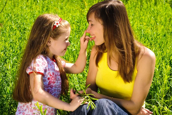 Usměvavá mladá maminka s malou dcerou — Stock fotografie