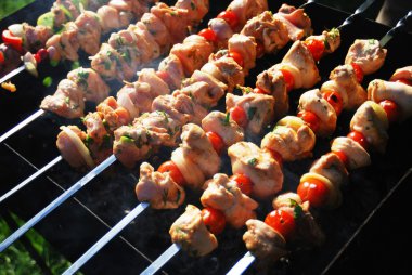 Grilled meat on metal skewers clipart