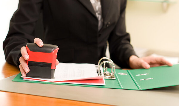 женская рука с печатью документов
