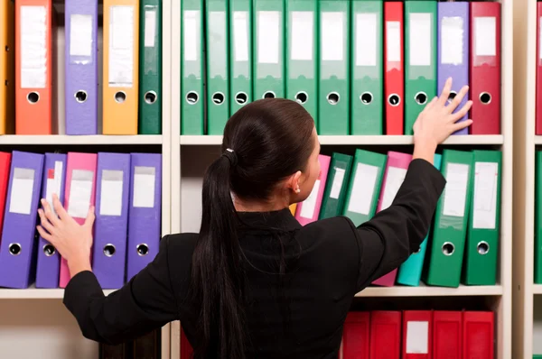 stock image Business woman in front of shelves with folders