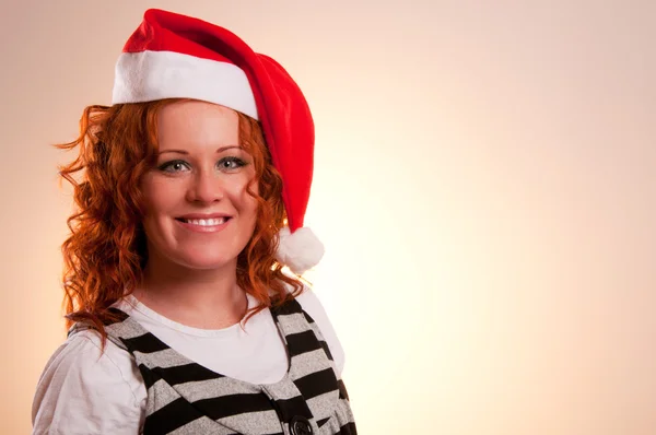 Noel Baba'nın şapkalı gülümseyen kadın — Stok fotoğraf