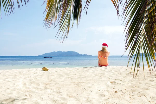 Giovane donna sulla spiaggia in cappello di Babbo Natale — Foto Stock