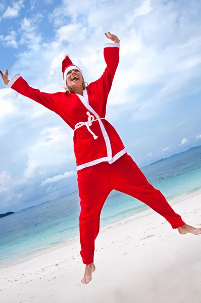 圣诞老人的服装在海滩上的年轻女子 — 图库照片
