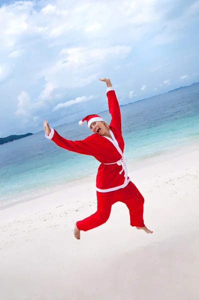 Mujer joven en la playa disfrazada de Santa Claus —  Fotos de Stock