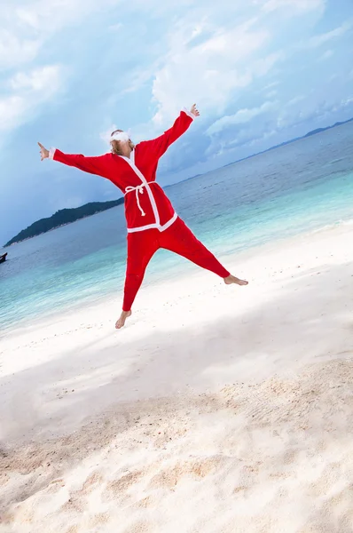 Mujer joven en la playa disfrazada de Santa Claus — Foto de Stock