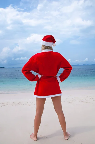 Jovem mulher na praia em traje de Papai Noel — Fotografia de Stock