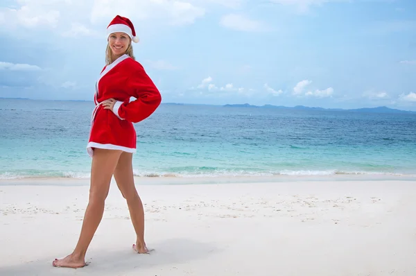 Young woman on the beach in santa's costume — Stock Photo, Image