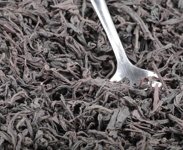 Black tee and teaspoon — Stock Photo, Image