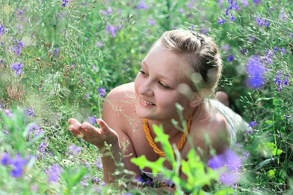 stock image Young girl lying among the flowers