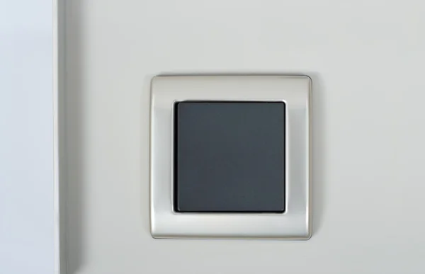 Vypínač na zdi s šedé tlačítko na stříbrný rám — Stock fotografie