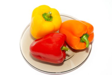 Three colored paprika on the plate on white background. clipart