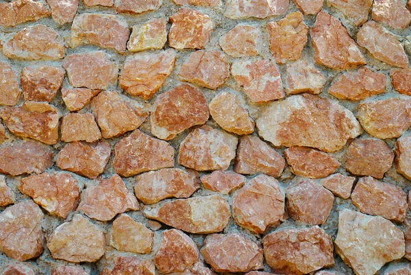 Un mur de pierres rouges texturées . — Photo