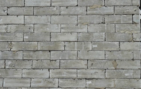 Eine Wand aus strukturierten grauen Bausteinen. — Stockfoto