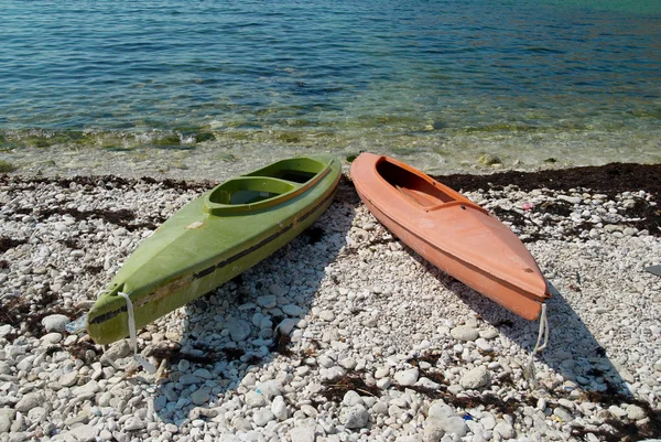 Twee kleuren kajaks op het strand. — Stockfoto