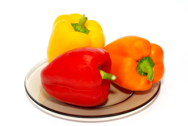 Tre paprica colorata sul piatto su sfondo bianco . — Foto Stock