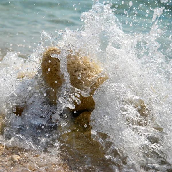 Камни в волнах и морская пена . — стоковое фото