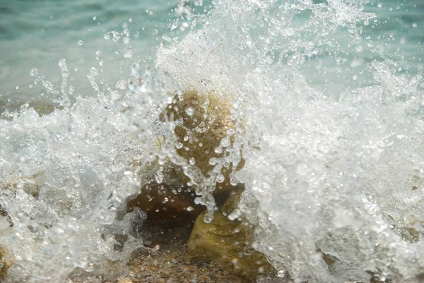 Rochers dans les vagues et mousse de mer . — Photo