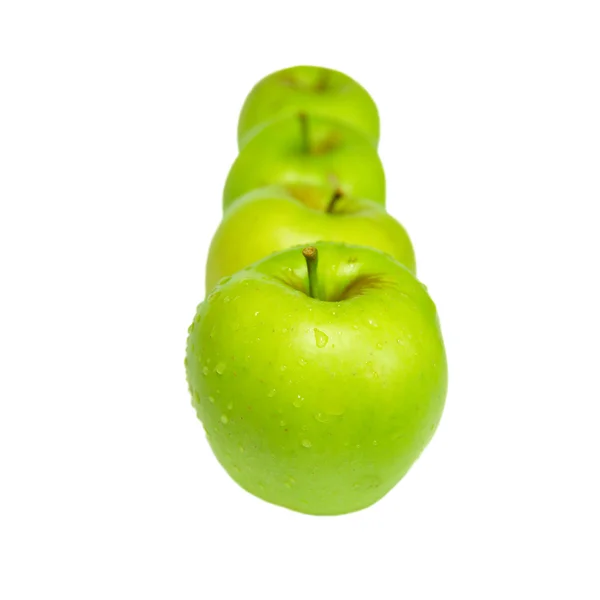 Ряд зеленых яблок изолированы на белом . — стоковое фото