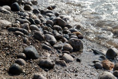 dalgalar ve deniz köpüğü kayalarda.