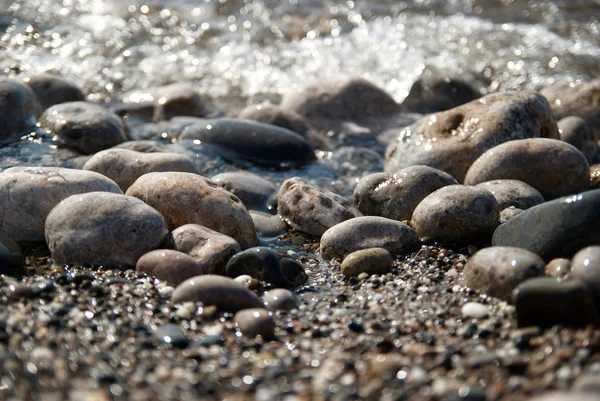 Камни в волнах и морская пена . — стоковое фото