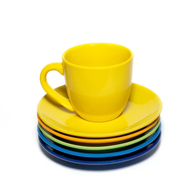 Gelbe Teetasse und Stapel Untertassen isoliert auf weiß. — Stockfoto